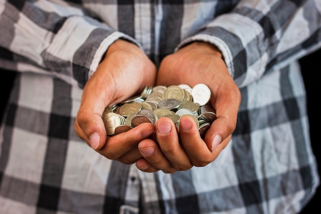 Hombre sujetando en manos ahorrando monedas