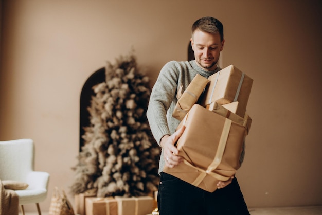 Hombre sujetando un montón de regalos de Navidad