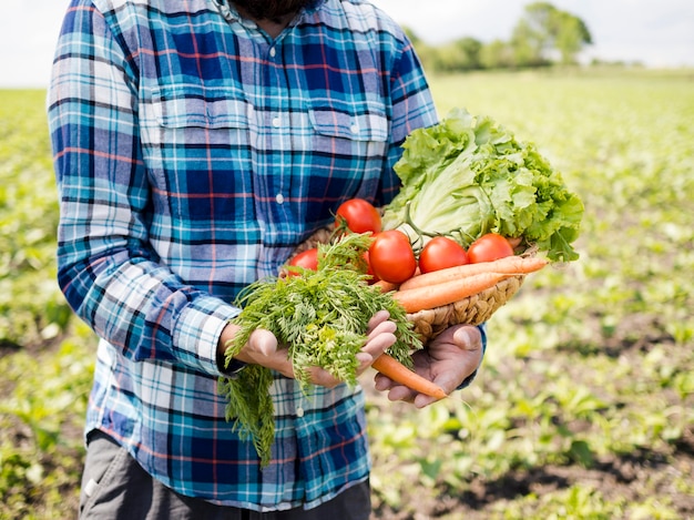 Hombre sujetando un montón de verduras