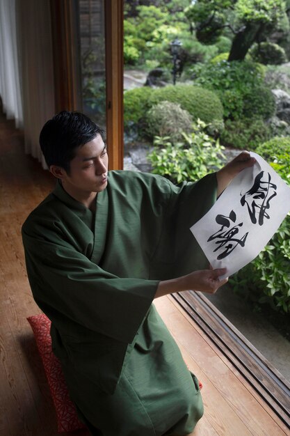 Hombre sujetando un papel con letra japonesa