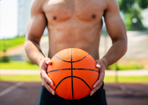 Hombre sujetando una pelota de tiro medio