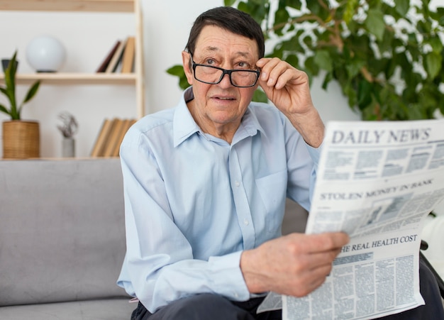 Hombre sujetando un periódico de tiro medio