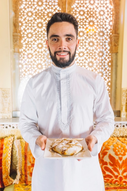 Hombre sujetando plato de comida arabe