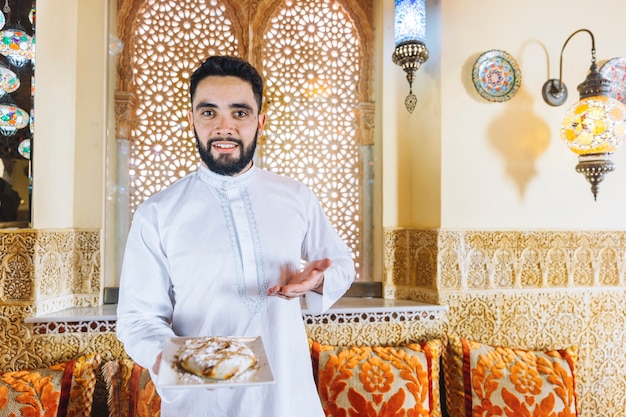 Hombre sujetando plato de comida arabe