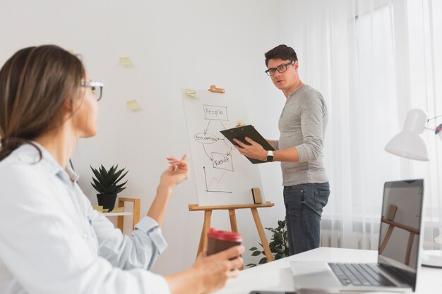 Hombre sujetando un portapapeles y escribiendo en un panel