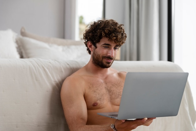 Foto gratuita hombre sujetando un portátil de tiro medio