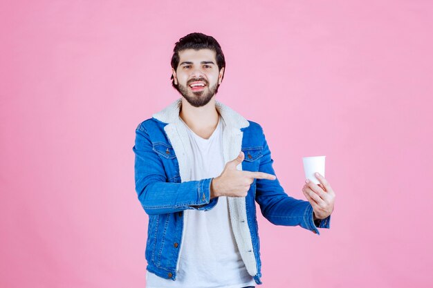 Hombre sujetando y presentando una nueva taza de café desechable