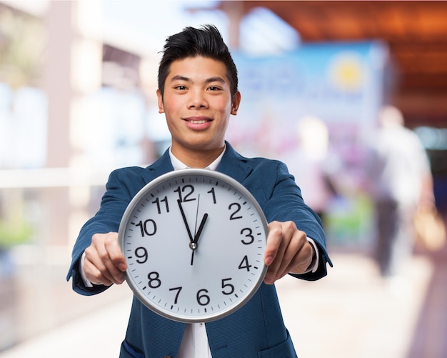 Foto gratuita hombre sujetando un reloj grande