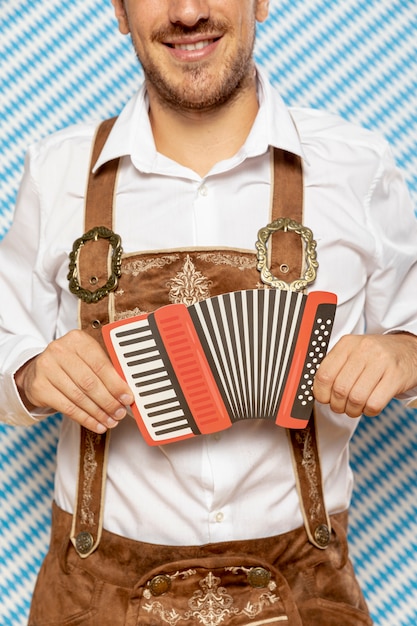 Foto gratuita hombre sujetando la réplica de bandoneón rojo