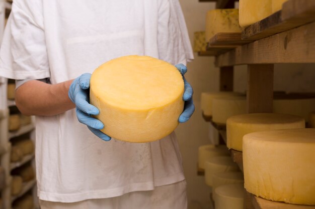 Hombre sujetando un rollo de queso