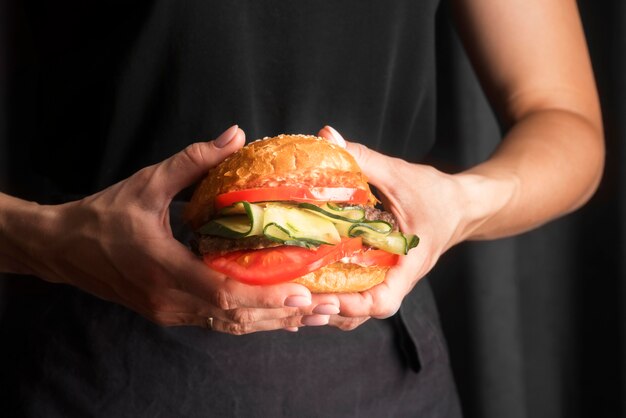 Hombre sujetando una sabrosa hamburguesa