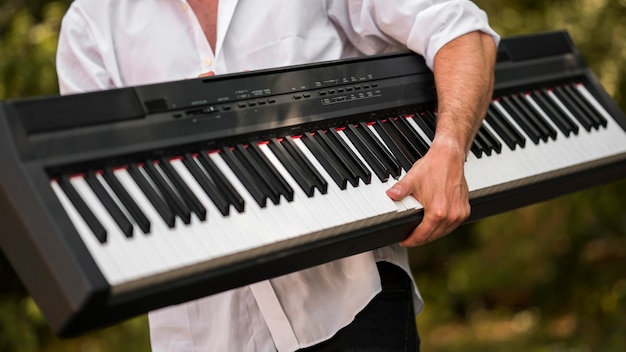 Hombre sujetando su piano digital