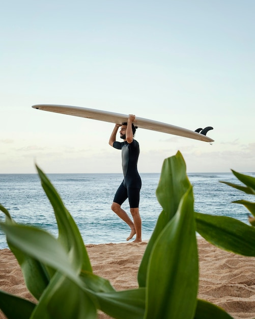 Hombre sujetando su tabla de surf