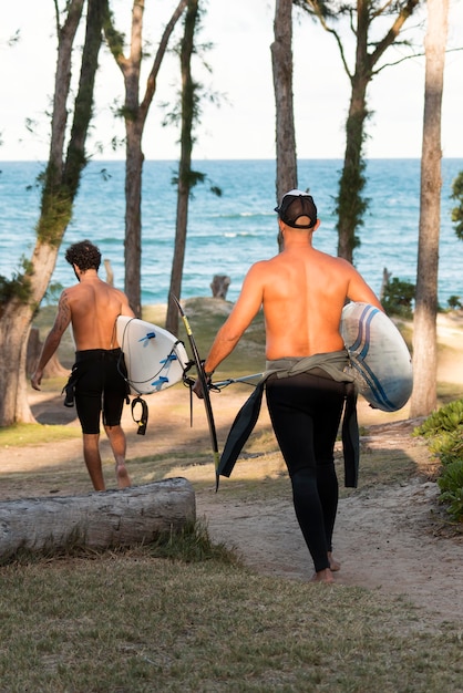 Foto gratuita hombre sujetando una tabla de surf al aire libre