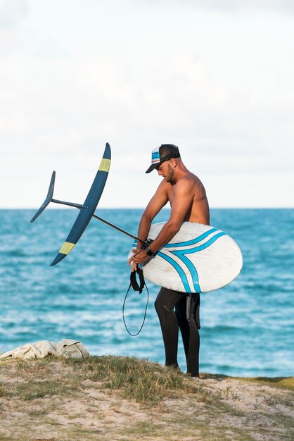 Hombre sujetando una tabla de surf al aire libre