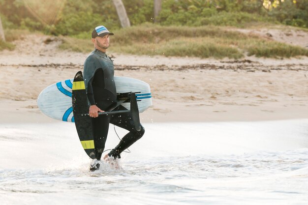 Hombre sujetando una tabla de surf al aire libre