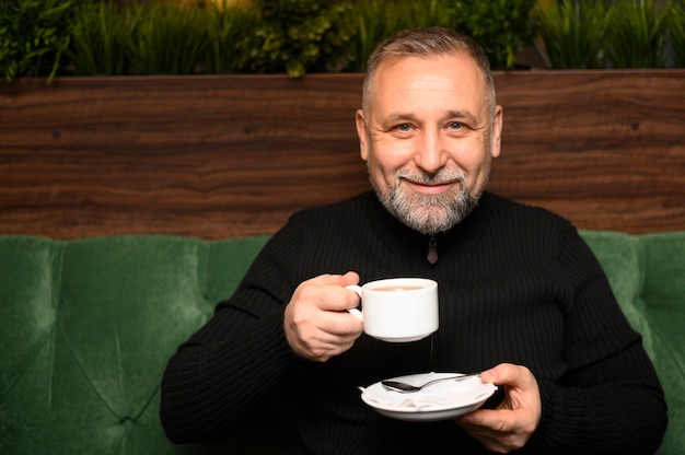 Foto gratuita hombre sujetando una taza de café en un restaurante