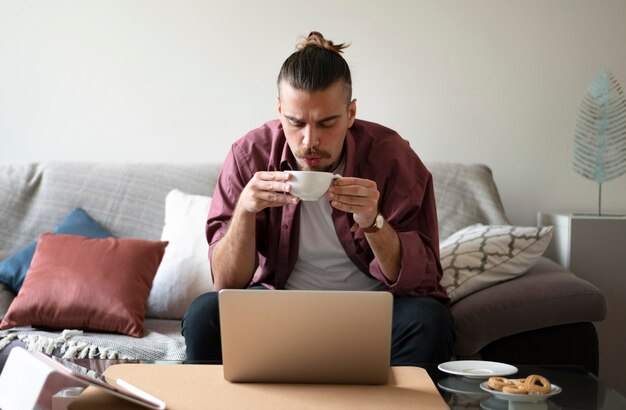 Hombre sujetando una taza de tiro medio