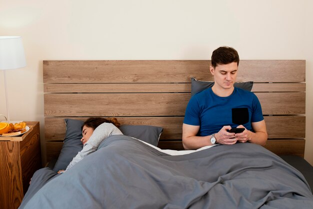 Hombre sujetando el teléfono de tiro medio