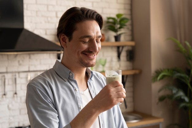 Hombre sujetando un vaso de tiro medio