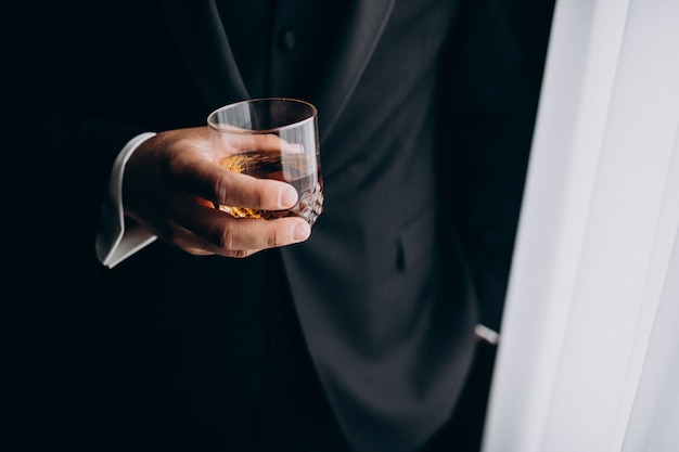 Hombre sujetando un vaso de whisky