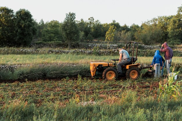 El hombre y sus hijos cultivando la cosecha.