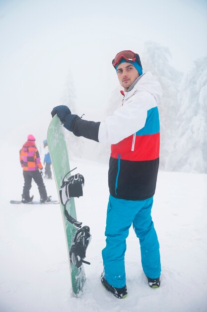 Hombre con tabla de snowboard durante el invierno