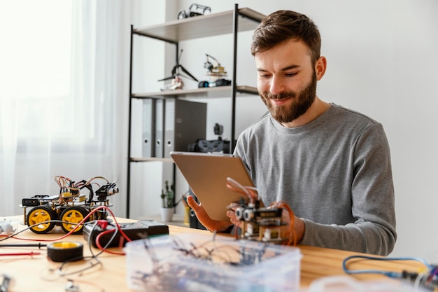 Foto gratuita hombre con tableta aprendiendo a hacer robot