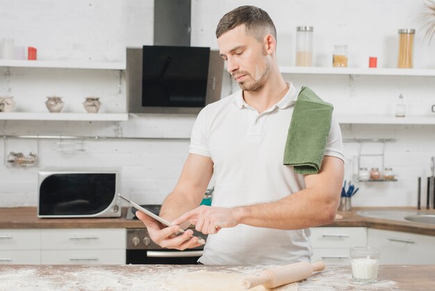 Hombre con tableta en cocina