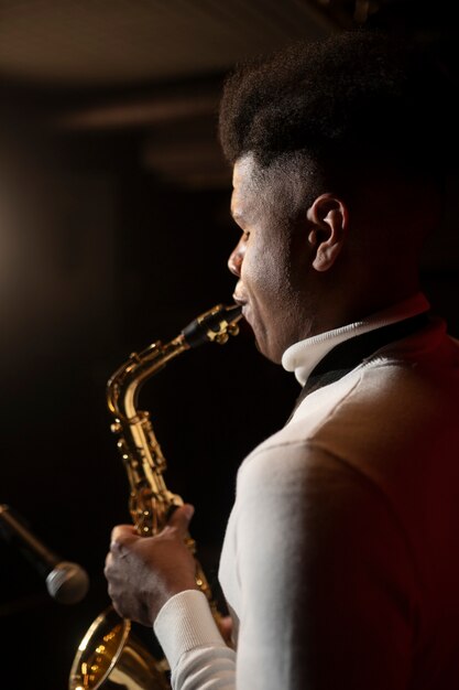 Hombre talentoso de tiro medio tocando el saxofón.