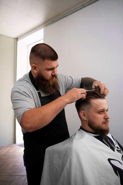 Hombre de talla grande de plano medio trabajando como estilista