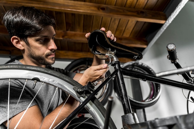 Hombre en taller creando bicicleta