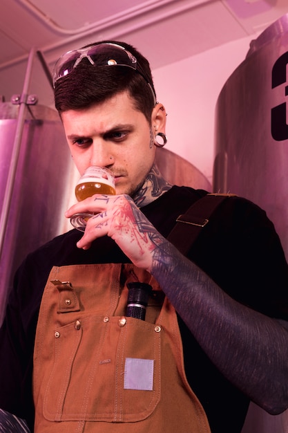 Hombre con tatuajes produciendo cerveza artesana