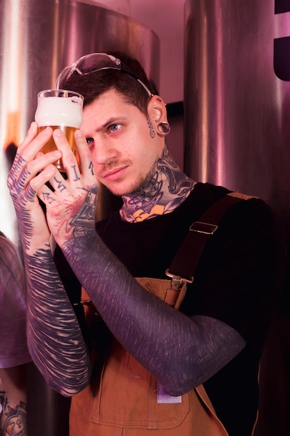 Hombre con tatuajes produciendo cerveza artesana