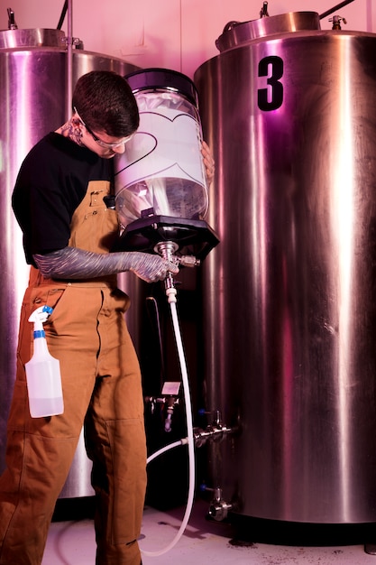 Foto gratuita hombre con tatuajes produciendo cerveza artesana