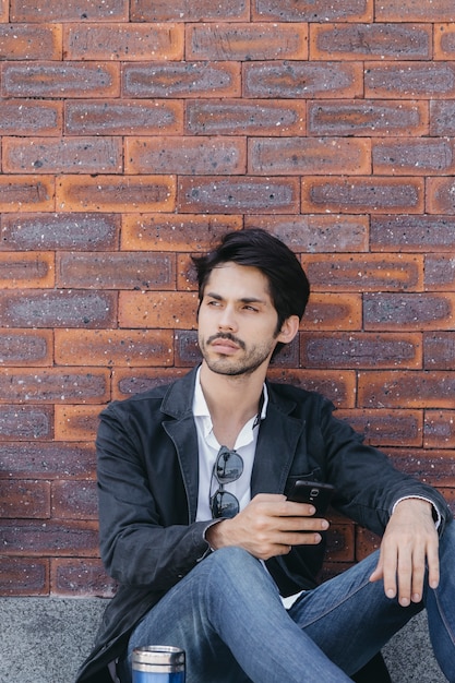 Hombre con teléfono inteligente mirando a otro lado