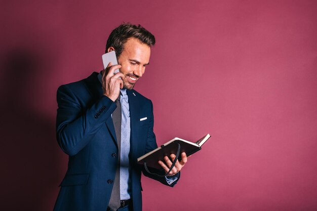 Hombre con teléfono móvil y una libreta