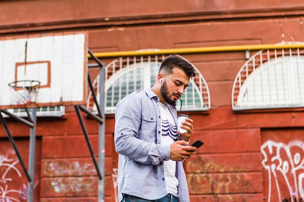 Hombre con teléfono móvil tomando café