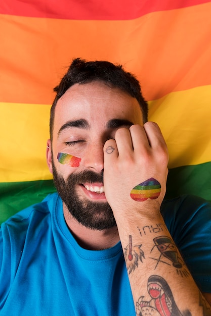 Hombre tendido en la bandera de LGBT