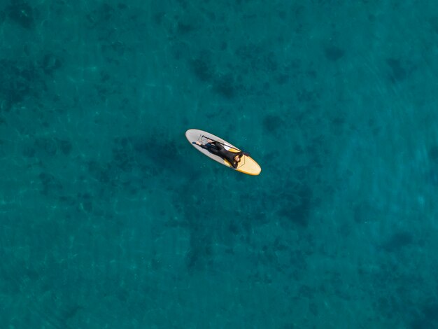 Hombre tendido en la vista superior de la tabla de surf