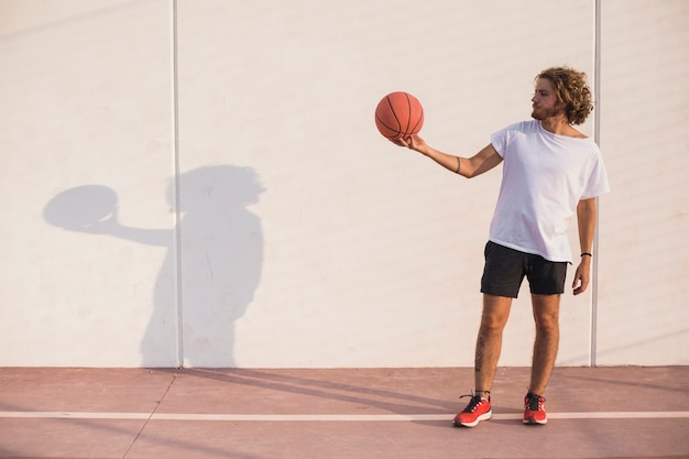 Hombre, tenencia, baloncesto, delante de, pared