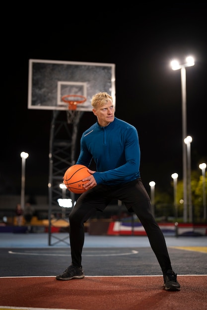 Hombre, tenencia, pelota de baloncesto, tiro completo