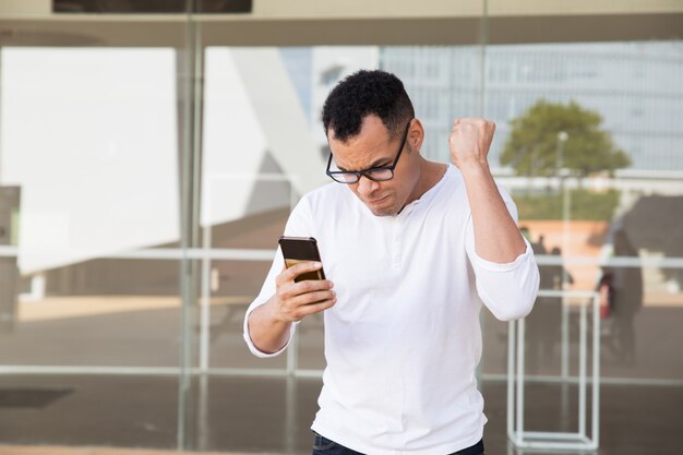 Hombre terminando la llamada, recibiendo noticias, celebrando el éxito.