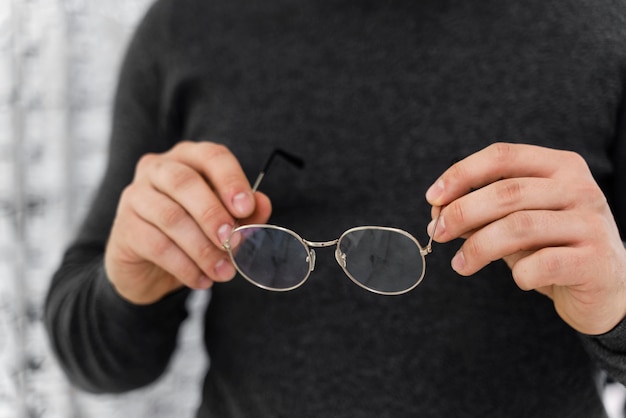 Foto gratuita hombre en la tienda probándose gafas de cerca