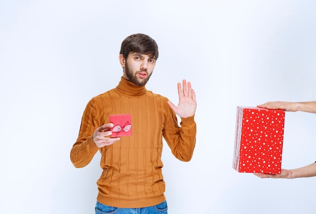 El hombre tiene una caja de regalo roja y se niega a tomar otra.