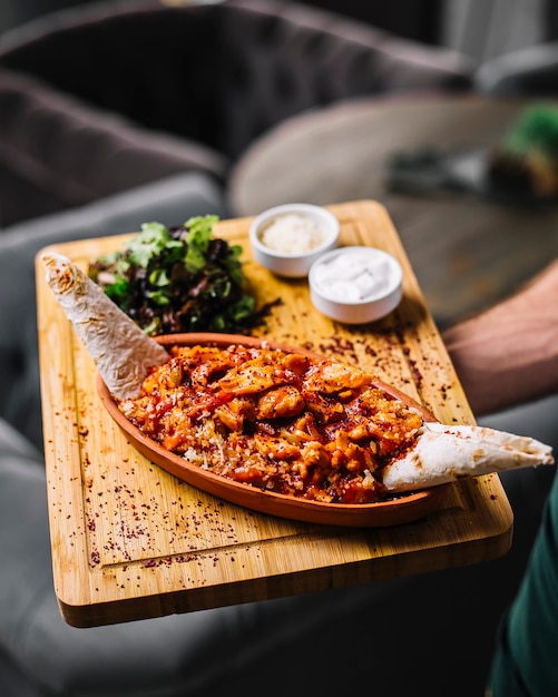 Foto gratuita el hombre tiene fajitas de mariscos langostinos verduras queso lavash ensalada verde crema agria vista lateral