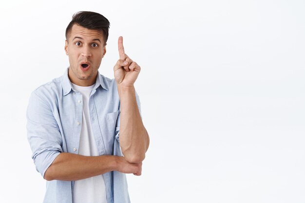 El hombre tiene una solución Adulto apuesto italiano con camisa casual levantando el dedo índice para decir sugerencia hablar durante la reunión obtuvo un excelente plan de pensamiento de planta de fondo blanco