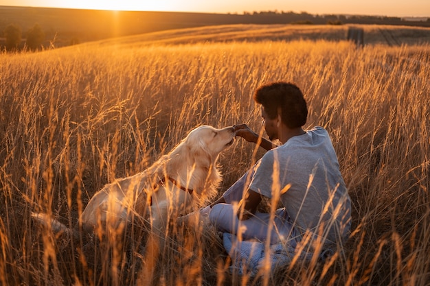 Foto gratuita hombre de tiro completo acariciando a un perro