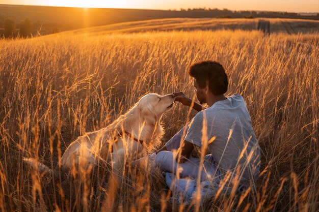 Hombre de tiro completo acariciando a un perro