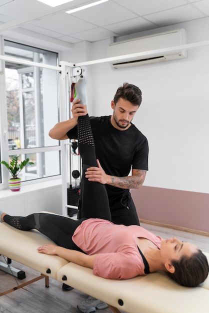 Foto gratuita hombre de tiro completo ayudando al paciente a recuperarse